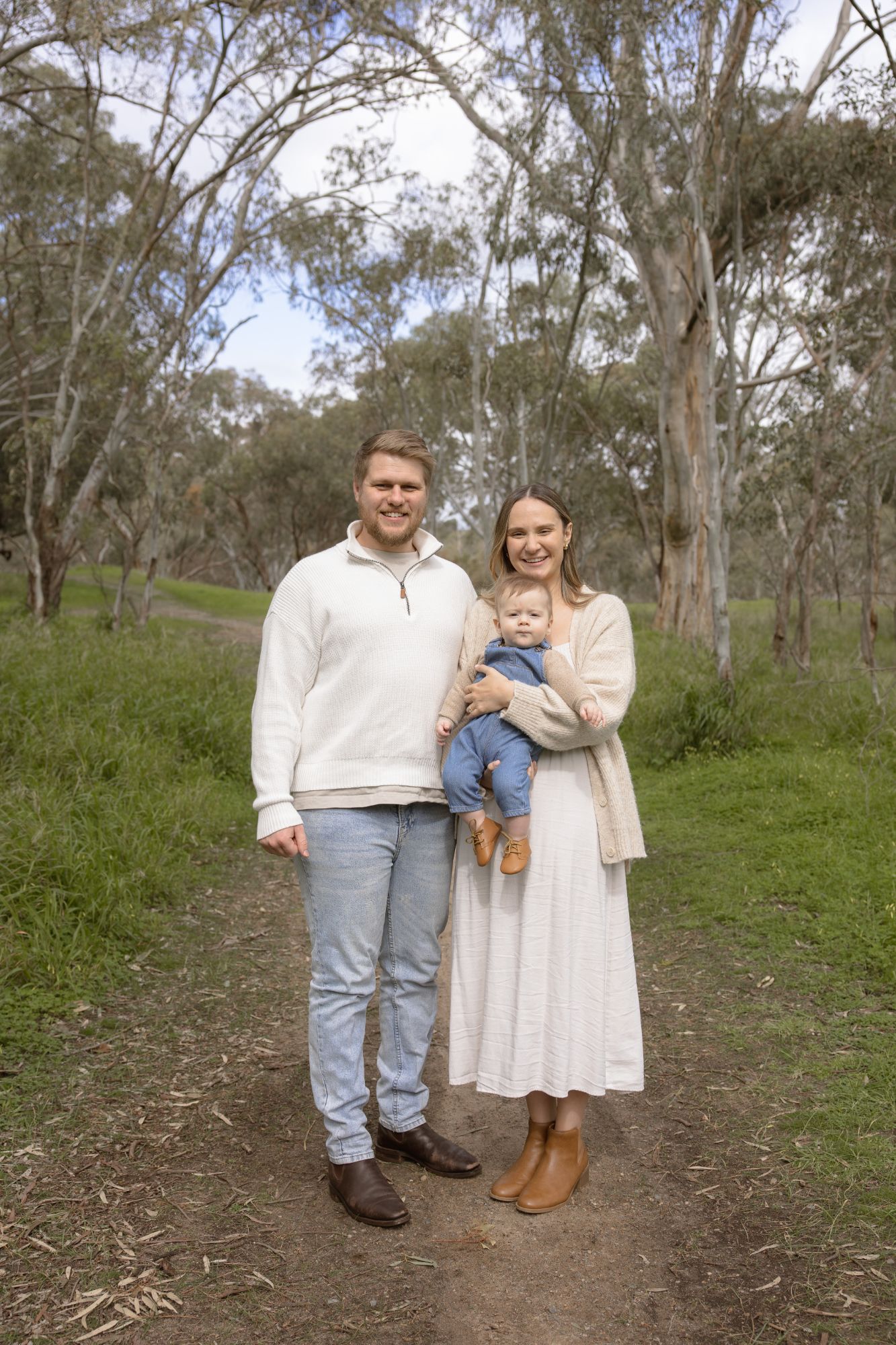 Couple with their baby on a bush track among gum trees
