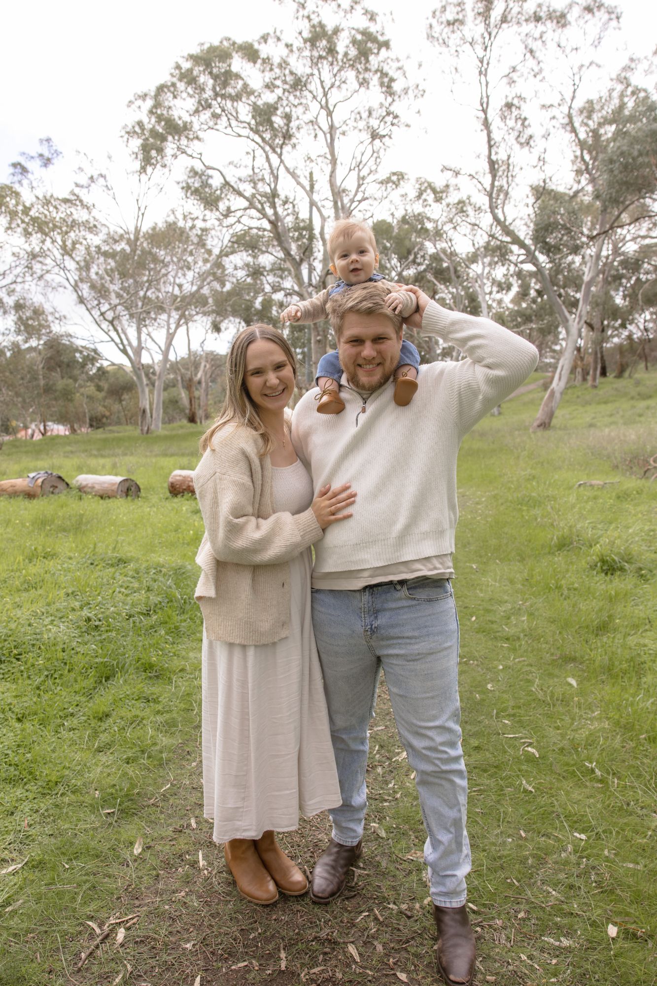 Mother laughing as the father carries their son on his shoulders