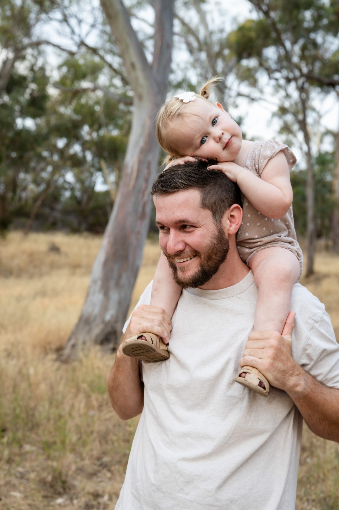 Daughter on her father’s shoulders, both smiling