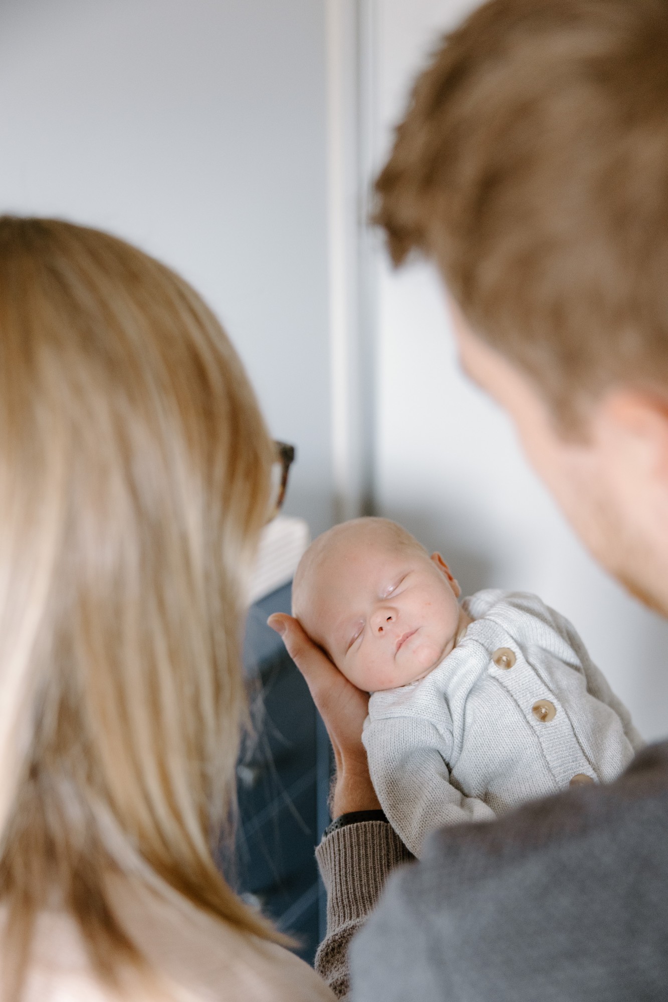 Father cradling his newborn as the mother looks on