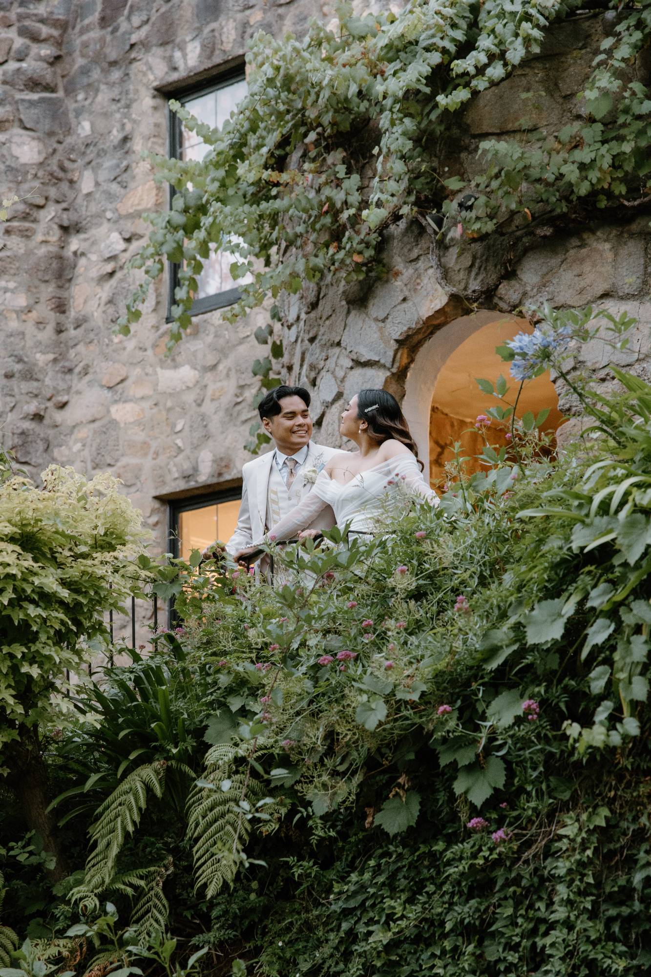 Couple on a stone balcony wrapped in greenery